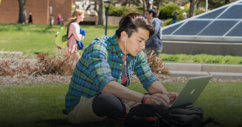student studying outside on grass 